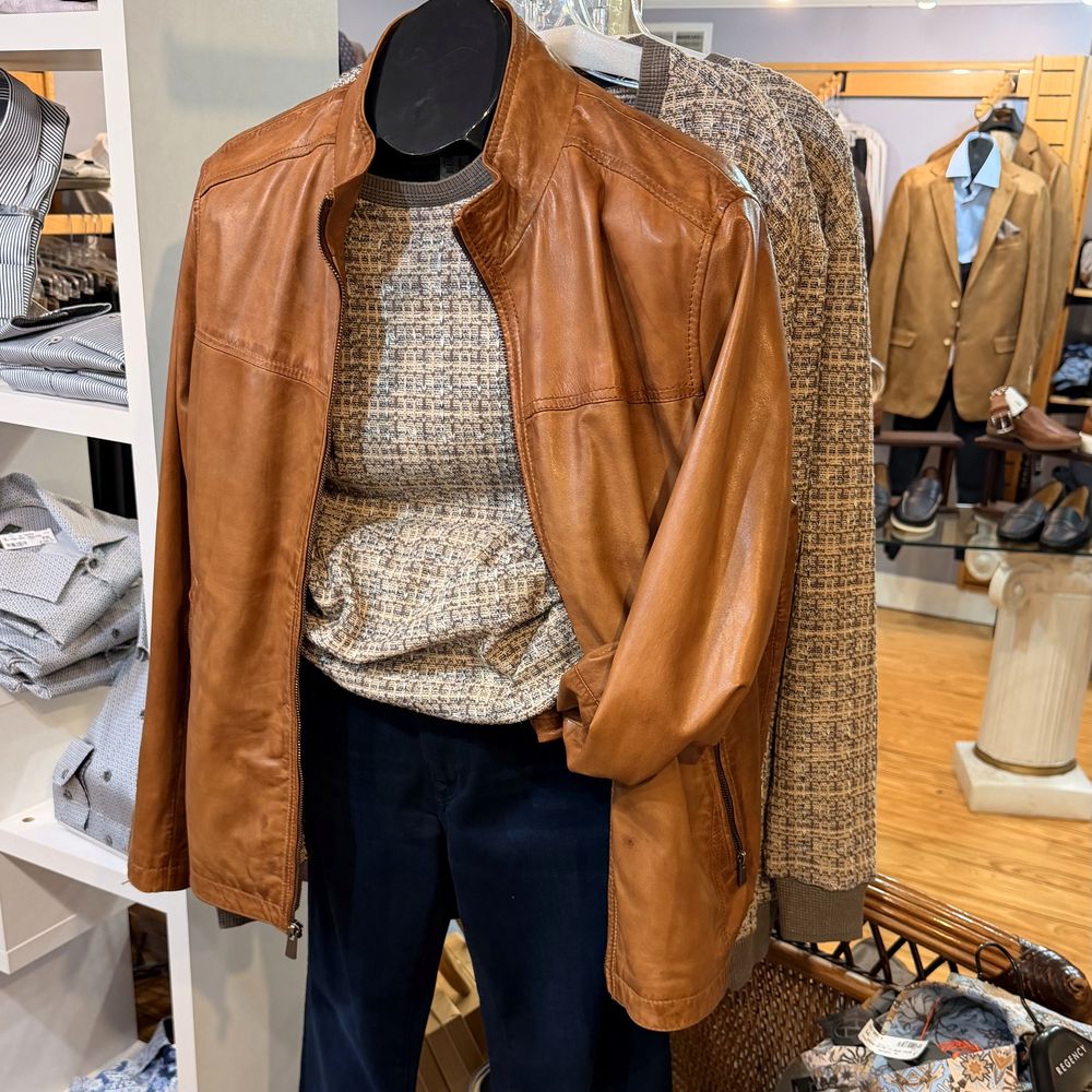 A cognac leather jacket layered over a textured knit