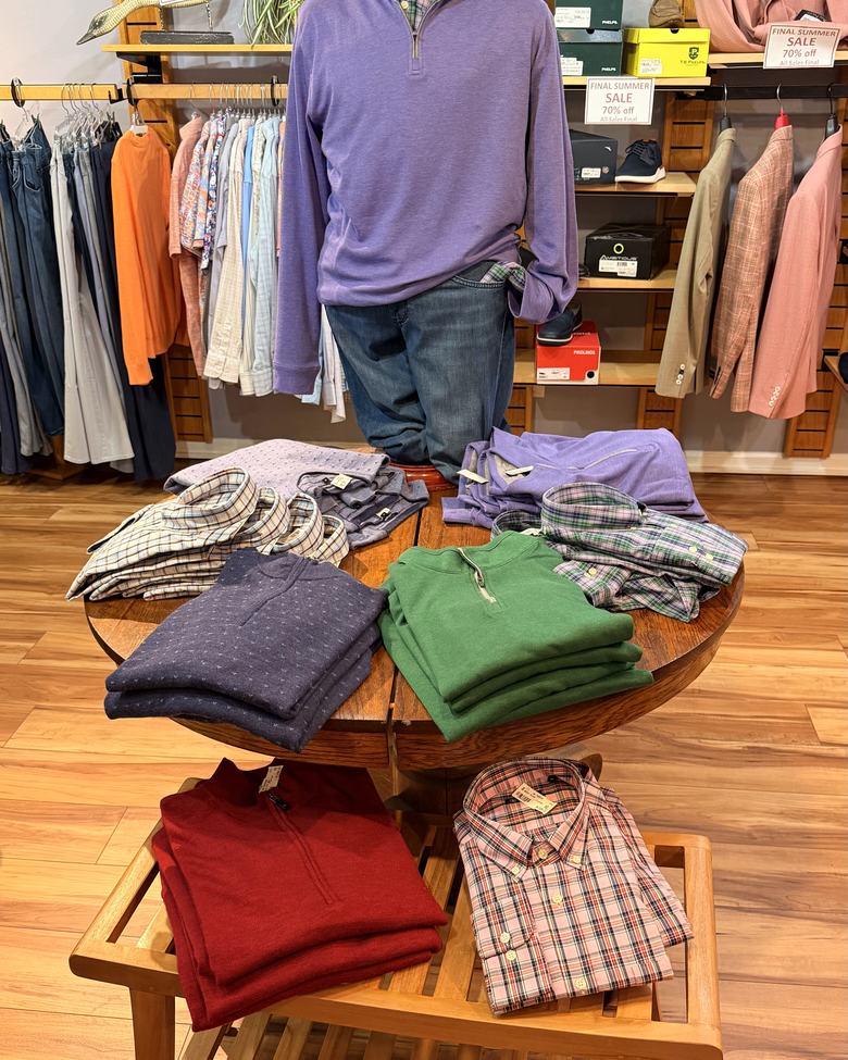 Quarter-zips and plaid shirts on the front table