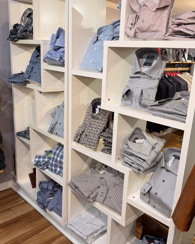 Folded dress shirts in white cubbies