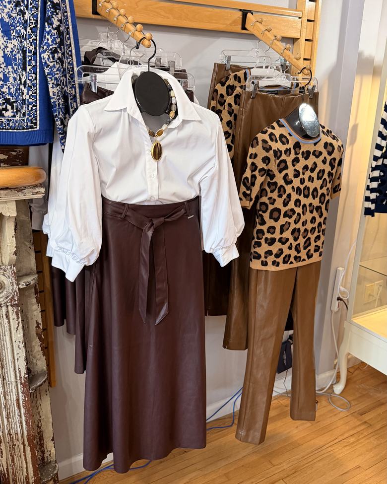 A white blouse with a leather skirt and leopard knit